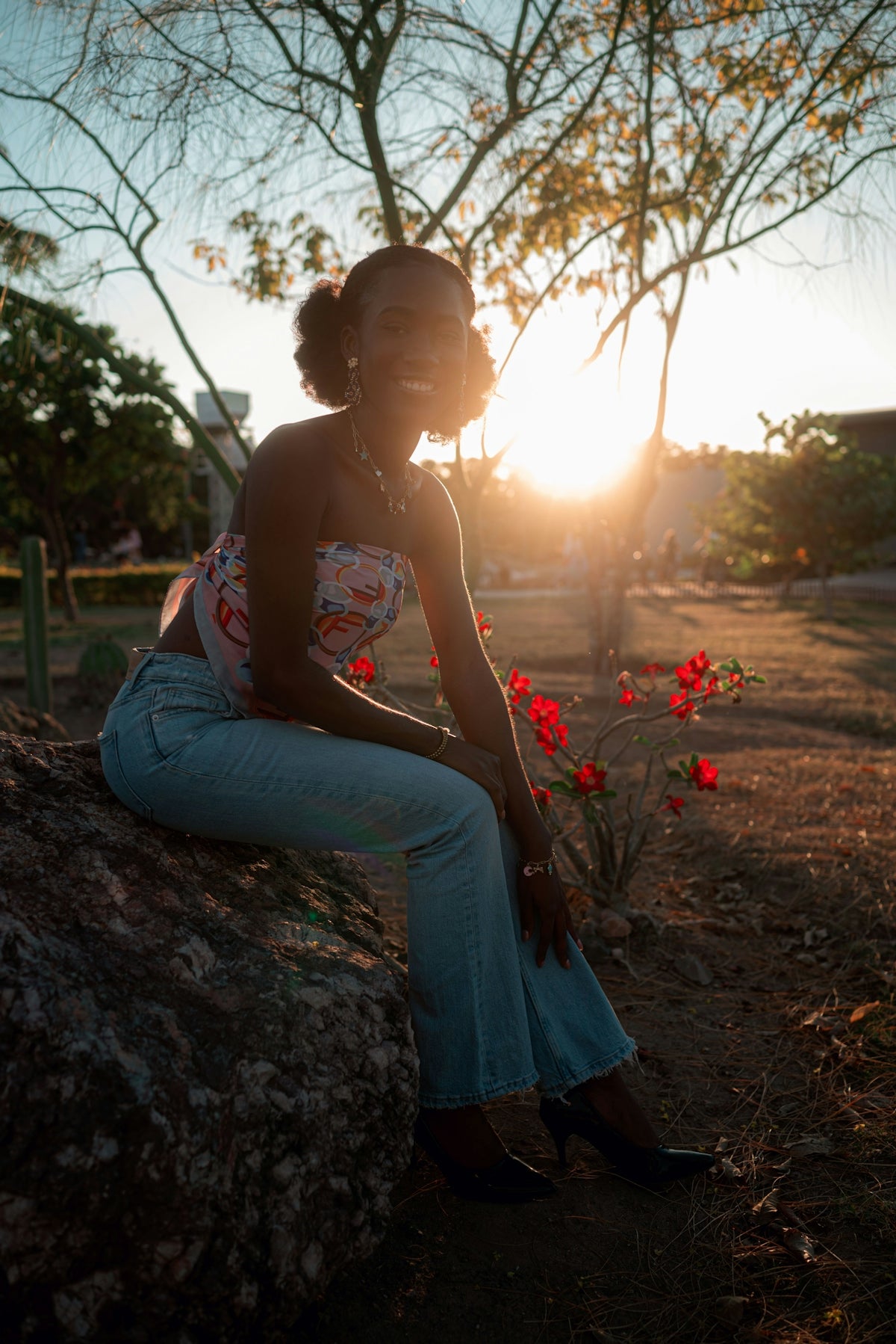Woman sitting on rock during sunset