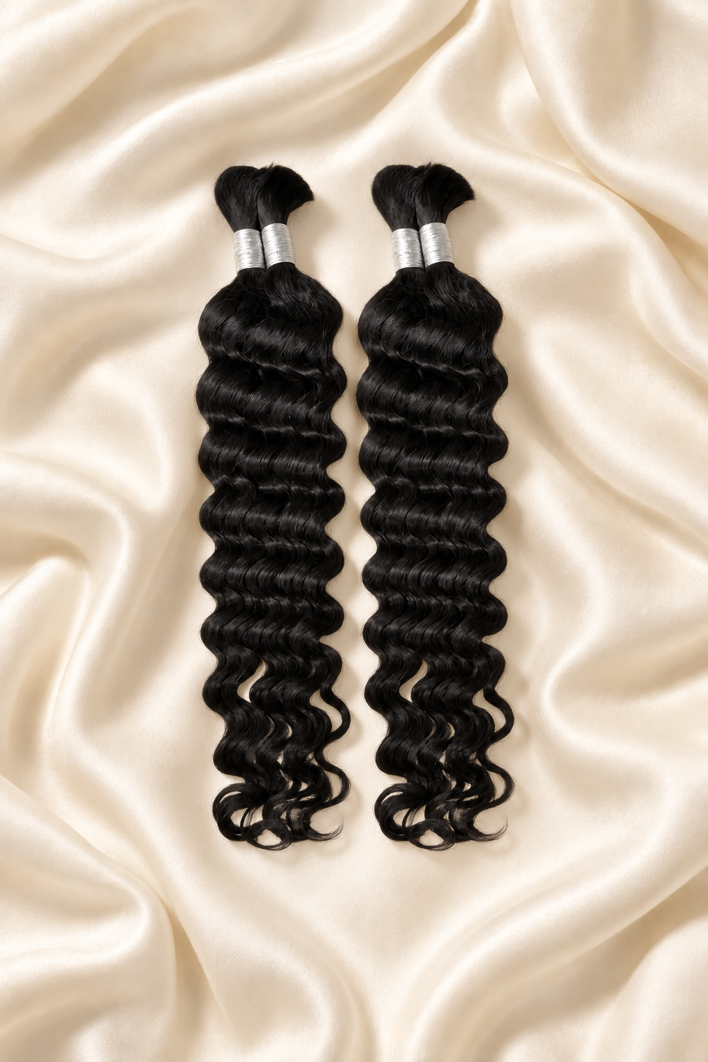 Two natural black deep wave human hair bundles for boho braids displayed on ivory silk