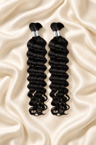 Two natural black deep wave human hair bundles for boho braids displayed on ivory silk