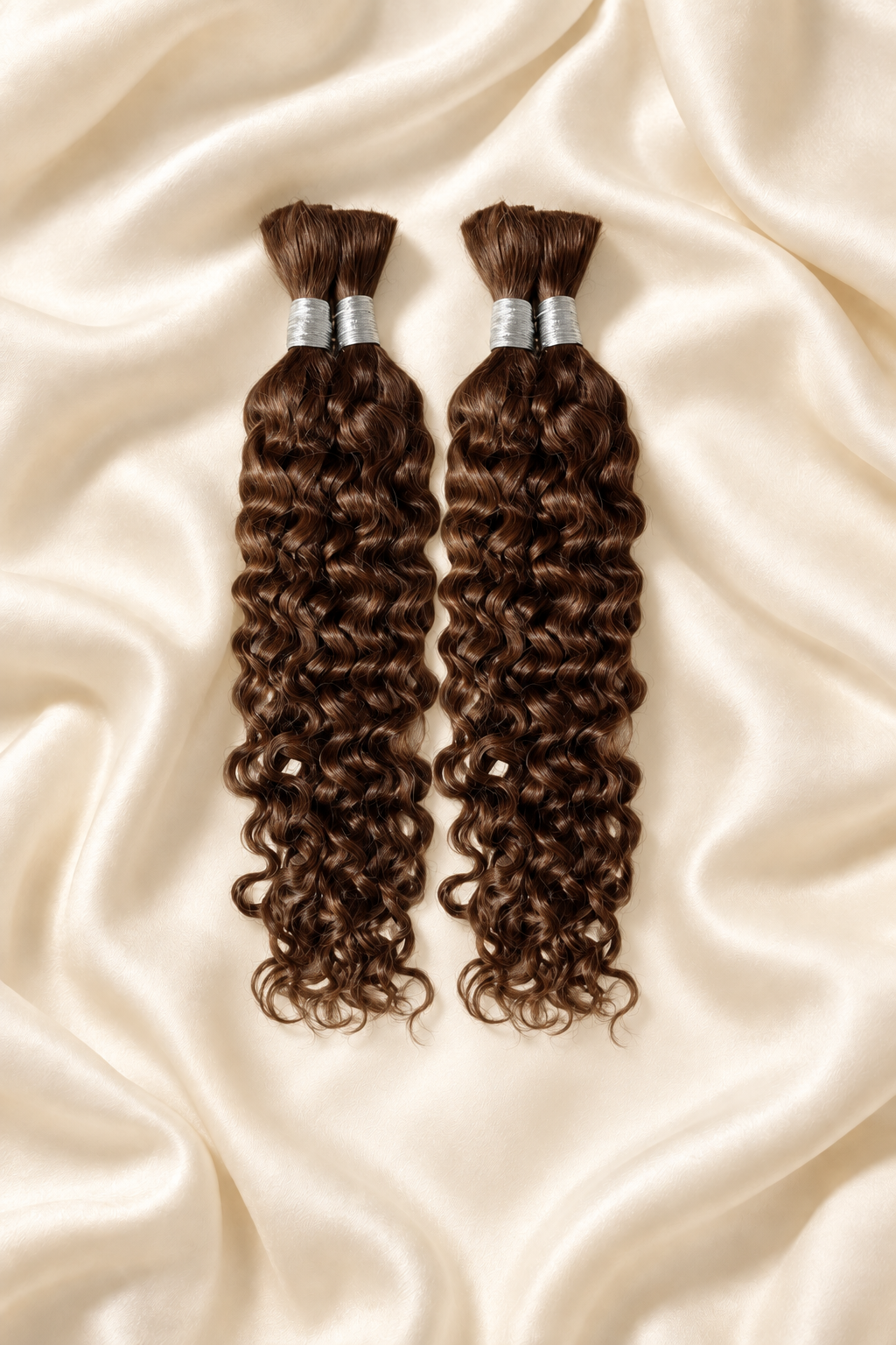 Two #30 auburn water wave human hair bundles for boho braids displayed on ivory silk
