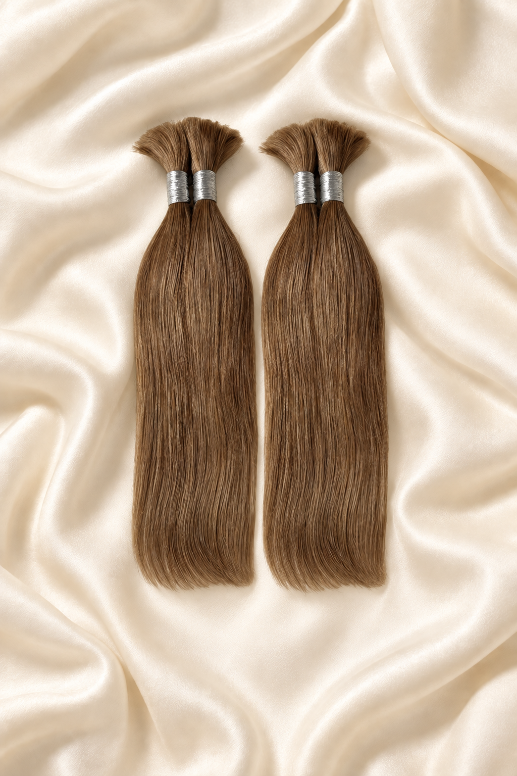 Two #27 honey blonde straight human hair bundles for boho braids displayed on ivory silk