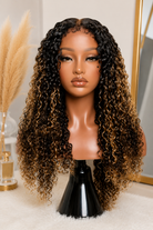 Model wearing a glueless curly human hair wig with brown highlights for everyday style